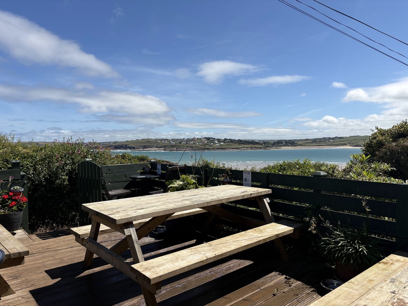 A picnic bench on the terrace with a coastal view