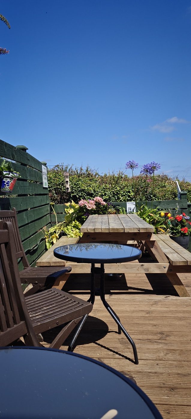 A bistro table among flowers on the terrace