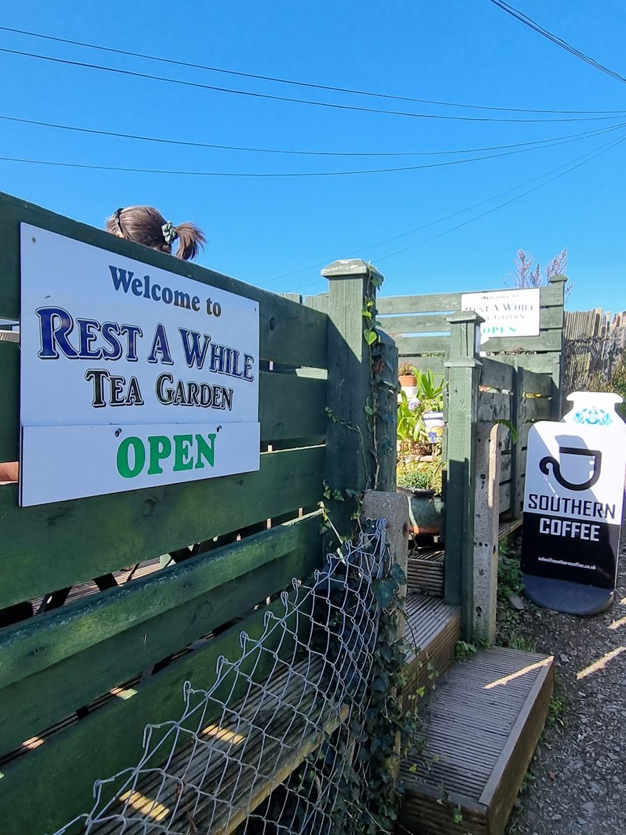 The Rest A While Tea Garden sign at the entrance, showing OPEN